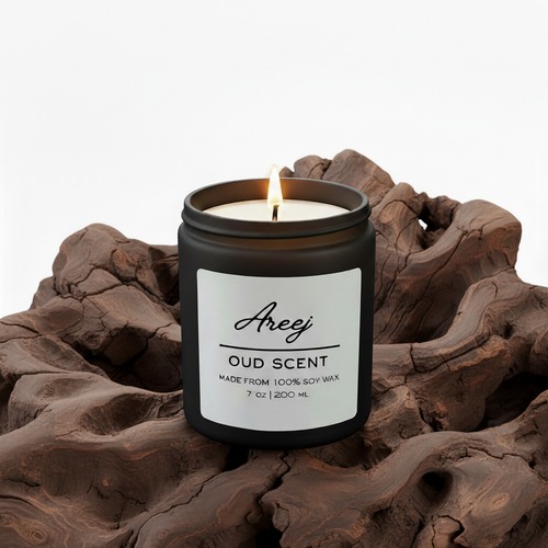 Candle labeled 'Areej Oud Scent' on a piece of oud wood with a white background